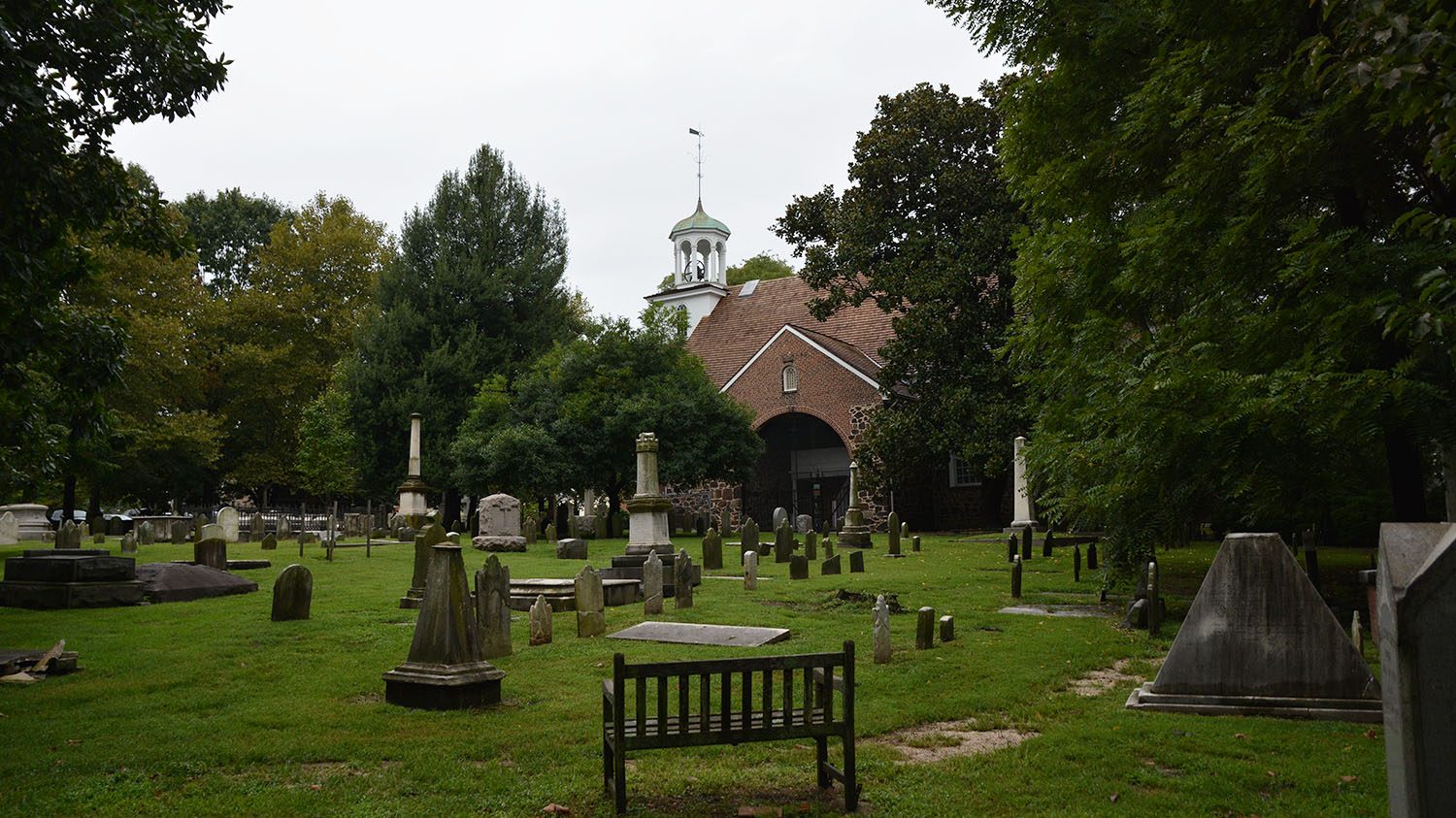 Old Swedes Church viewed from a distance, with many graves in the foreground.